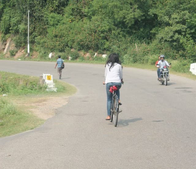 Pooja cycling on a Kashmir road