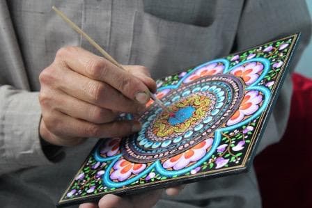 Close-up of artisan painting intricate Kashmiri motifs